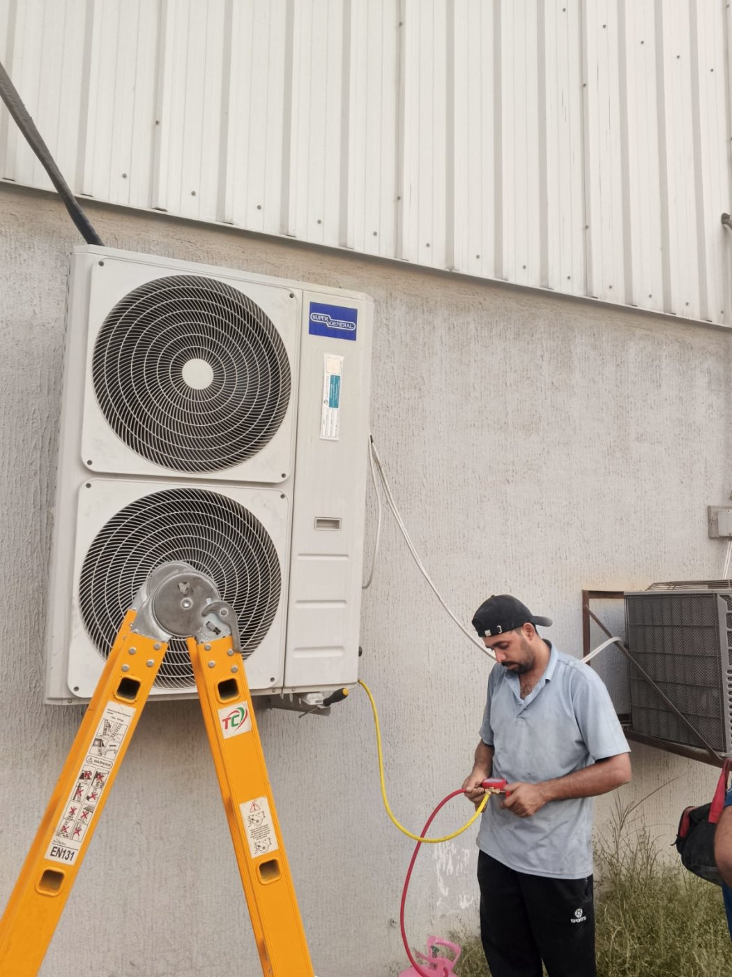 Smart AC Repair technician refilling refrigerant gas on a split-AC condenser in Dubai