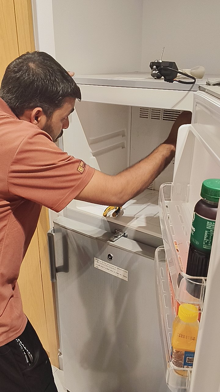 Smart AC Repair technician servicing a fridge freezer in Dubai